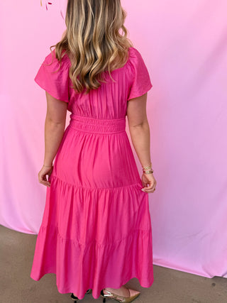Person wearing a pink dress against a pink background