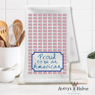 Kitchen towel with American flag pattern and 'Proud to be an American' text on a white kitchen counter.