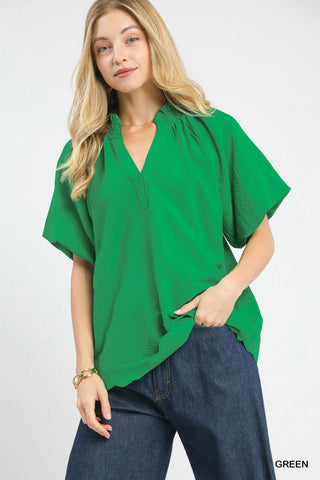 Woman wearing a green blouse and blue jeans on a white background