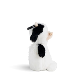 Plush toy cow with a tag on a white background