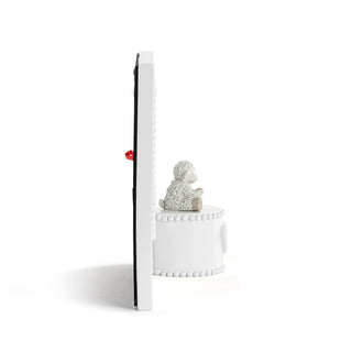 Decorative item with a small figurine on a white pedestal against a white background
