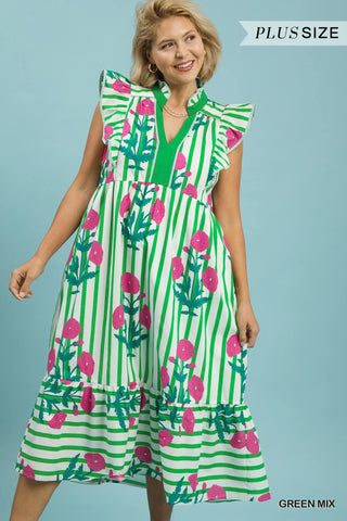 Woman wearing a green and pink floral dress with vertical stripes on a blue background