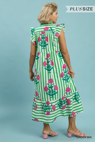 Woman wearing a green and pink dress with floral pattern on a light blue background
