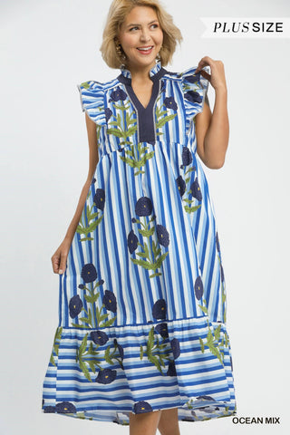 Woman wearing a blue and white striped dress with floral patterns on a white background