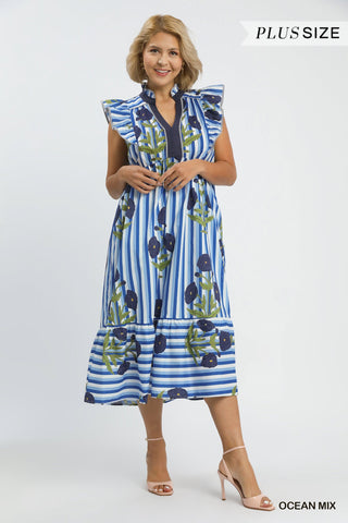 Woman wearing a blue and white striped dress with floral patterns on a white background
