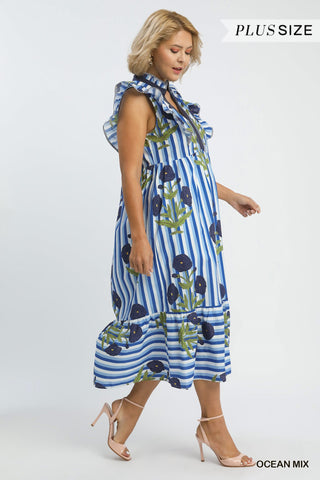 Woman wearing a blue and white striped dress with floral patterns on a white background