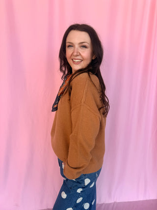 girl wearing a brown sweater on a pink background 