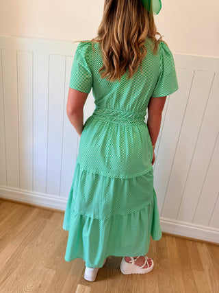 Woman wearing a green dress with a white wall background