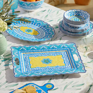 Colorful ceramic plates and tray on a patterned tablecloth