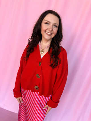 girl wearing a red sweater on a pink background