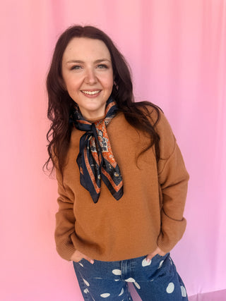 girl wearing a brown sweater on a pink background 