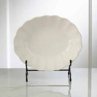 White ceramic plate on a black stand against a white background