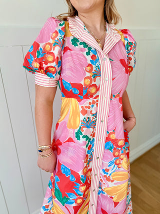 Person wearing a colorful floral dress with a white background