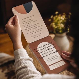 Person holding a book with text inside, blurred background with flowers
