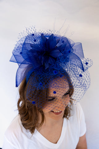 Woman wearing a blue decorative headpiece with a white background