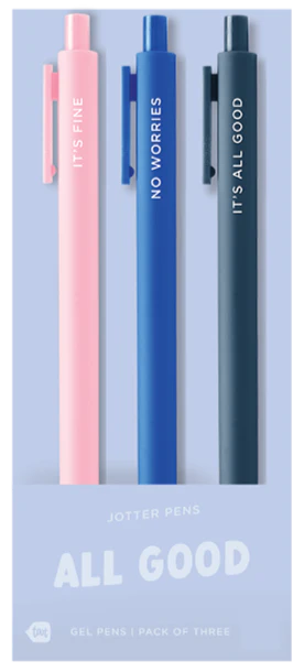 Three pens in pink, blue, and gray with motivational text in a packaging box on a light purple background.