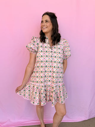 Woman wearing a floral dress lying on a pink surface