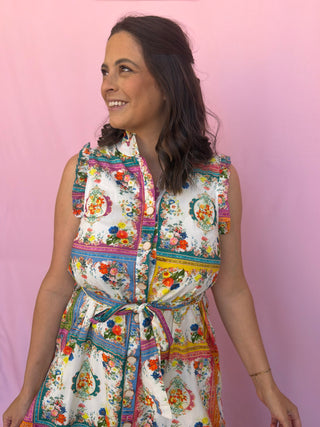 Woman wearing a colorful patterned dress against a pink background