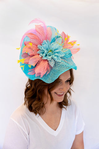 Woman wearing a colorful floral hat against a white background