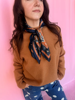 girl wearing a brown sweater on a pink background 