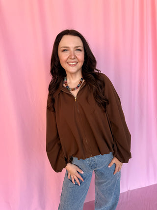 girl wearing a brown shirt on a pink background 