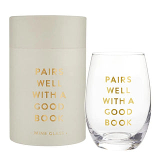 Clear wine glass with 'Pairs Well with a Good Book' text and matching cylindrical container on a white background