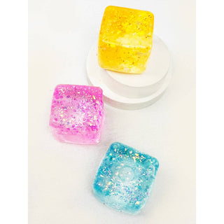 Three colorful glittery soap bars on a white background
