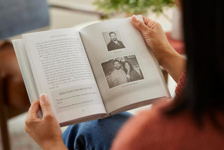 Person reading a book with photos and text on a blurred background