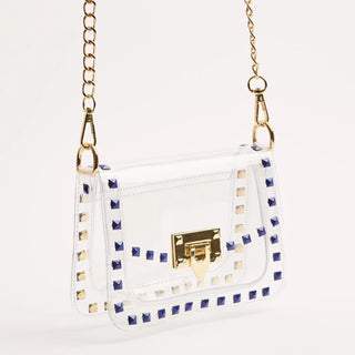 White handbag with gold accents and blue stud details on a white background