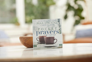 Book titled 'Pocket Prayers for Friends' by Max Lucado and Betty St. Amant on a table with a blurred background