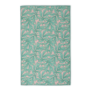 Patterned towel with green leaf design on a pink background