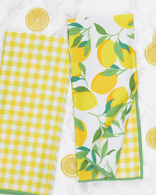 Two kitchen towels with lemon and checkered patterns on a white background