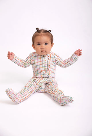 Baby wearing a plaid outfit on a white background