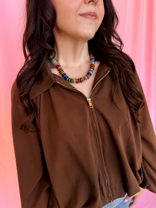 girl wearing a brown shirt on a pink background 