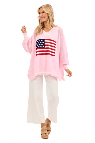 Woman wearing a pink sweater with an American flag design on a white background
