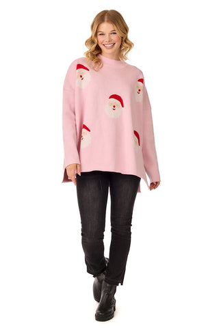 Woman wearing a pink sweater with Santa Claus designs on a white background