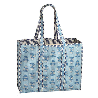 Tote bag with blue floral pattern and striped handle on a white background
