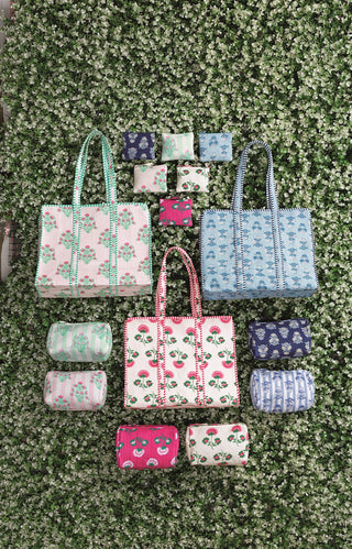 Collection of handbags and pouches on a green textured surface