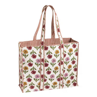 A canvas tote bag with a cream background, decorated with a colorful floral pattern in shades of red, pink, yellow, and green, featuring red-and-white striped handles and trim.