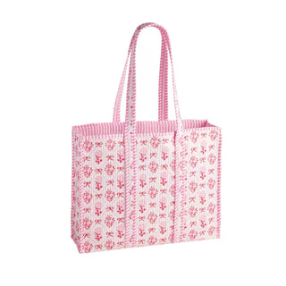 Pink tote bag with bow pattern on a white background