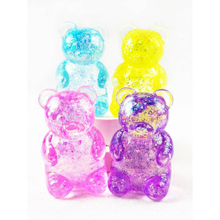 Four translucent teddy bear-shaped containers filled with glitter in pink, purple, blue, and yellow, arranged on a white background.