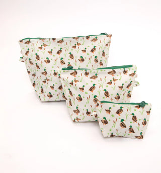 Three fabric zippered pouches in different sizes, featuring a repeating pattern of mallards and reeds on an off-white background with green zipper pulls.