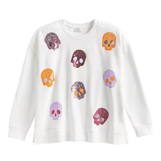 A white long-sleeve crewneck sweatshirt featuring an all-over print of colorful glittery skulls in orange, purple, and pink.