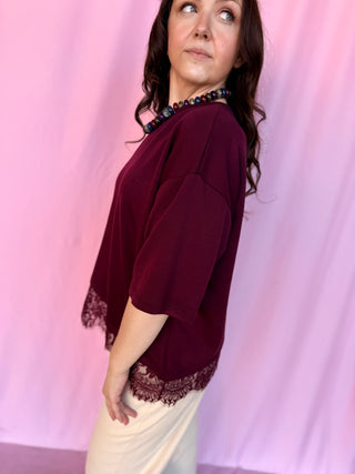 girl wearing red top on a pink background 