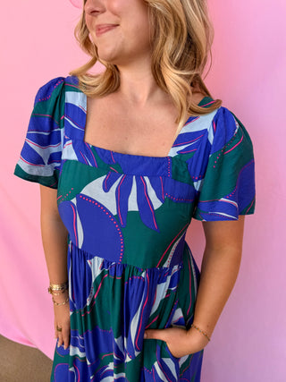 Woman wearing a colorful dress with a pink background