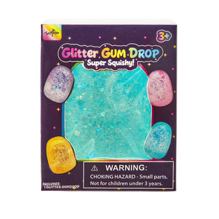 A boxed craft product labeled 'Glitter GUM DROP Super Squishy!' on a plain white background. The package shows a large turquoise glittery square in the center with four smaller glittery eggs around it in lavender, pink, and yellow.
