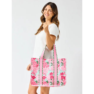 Woman holding a floral tote bag against a white background