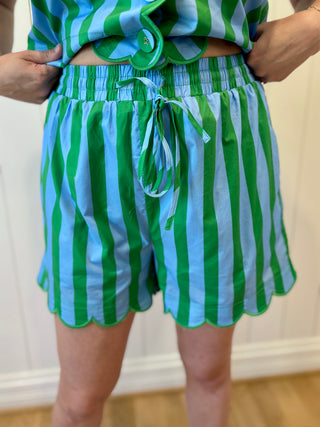 Green and blue striped outfit with a matching skirt on a neutral background