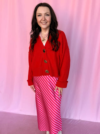 girl wearing a red sweater on a pink background