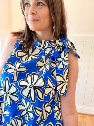 Woman wearing a blue floral dress with a white background